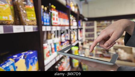 Digitalen Verbund von Hand unter Bild von Produkten mit digital-Tablette im Kaufhaus Stockfoto