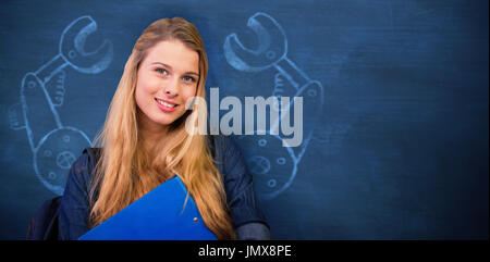 Hübsche Studentin in der Bibliothek vor blauem Hintergrund Stockfoto