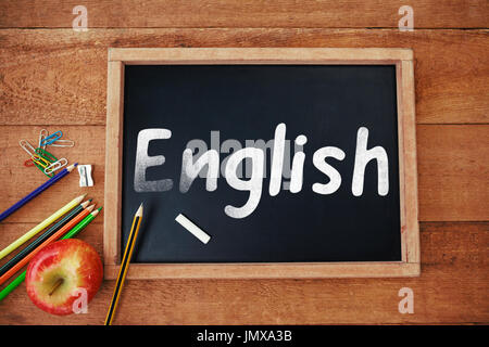 Englischer Text auf weißem Hintergrund gegen Draufsicht von Blackboard mit Apfel und Bleistifte Stockfoto