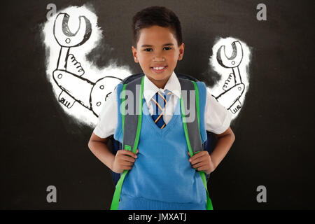 Porträt der Schüler tragen Schultasche vor weißem Hintergrund gegen Tafel Stockfoto