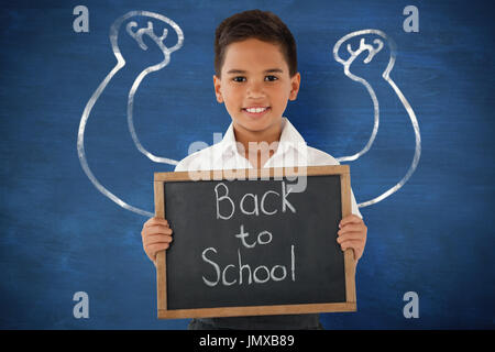 Schüler mit Schiefer mit Text auf weißem Hintergrund vor blauem Hintergrund Stockfoto