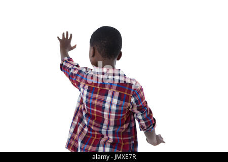 Rückansicht des jungen, die vorgibt, eine unsichtbare Touchscreen vor weißem Hintergrund Stockfoto