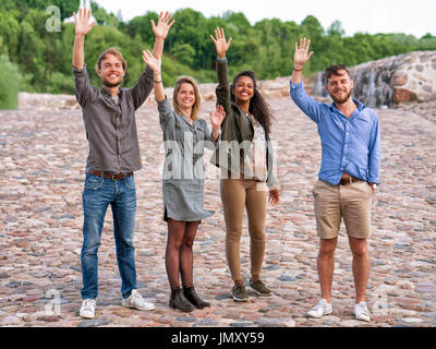 Gruppe junger Freunde winken ihren Händen als eine Geste der Gruß Konzept Stockfoto