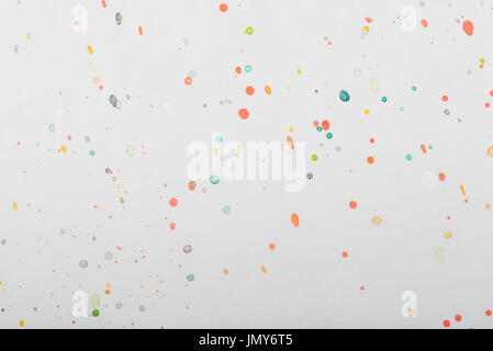 Spritzer Farbe Tropfen Farbe auf grau Papierhintergrund Stockfoto