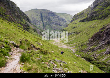 Sehen Sie unten verdeckt oder verlorene Tal (Coire Gabhail) mit Wanderer zu Fuß weg vom Glen Coe-Pass. Glencoe, Lachabar, Highland, Schottland, UK Stockfoto