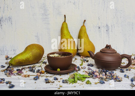 Kräuter und Blumen Tee. Stillleben-Cup, ein Wasserkocher und Birne zum Nachtisch. Hintergrund-weißen Putz an der Wand. Es ist möglich, große Druckformat. Stockfoto