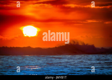 gefüllt mit Farben der marine tropischen Sonnenuntergang. Wave Splash ist am Strand gerollt. Stockfoto