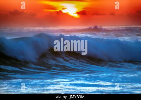 gefüllt mit Farben der marine tropischen Sonnenuntergang. Wave Splash ist am Strand gerollt. Stockfoto