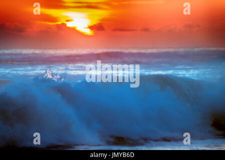 gefüllt mit Farben der marine tropischen Sonnenuntergang. Wave Splash ist am Strand gerollt. Stockfoto