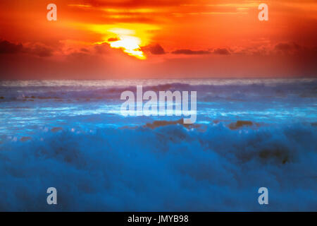 gefüllt mit Farben der marine tropischen Sonnenuntergang. Wave Splash ist am Strand gerollt. Stockfoto