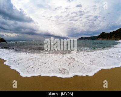 Blick am Strand an einem stürmischen Tag, das Meer ist stark verschoben, und der Himmel voller schwarz und bedrohliche Wolken Stockfoto