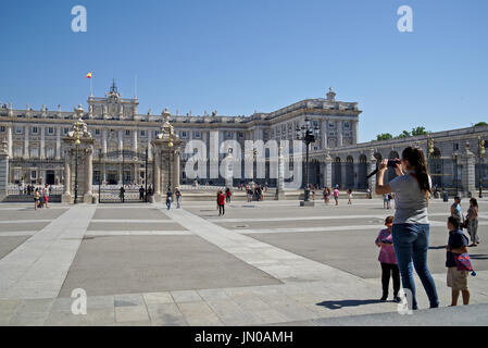 Nehmen Gruppe von Touristen Fotos von Palacio Real (Königlicher Palast) in Madrid, Spanien, in einer sehr sonnigen Tag mit ungetrübter blauer Himmel. Stockfoto