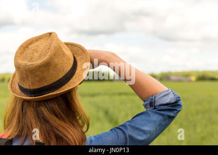 Frau mit Hut, mit Blick auf Wiese, outdoor-Aktivitäten, Wandern Stockfoto