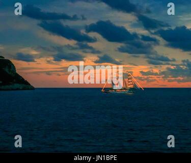 Tyrrhenischen Meer, Italien. 13. Oktober 2004. Bei Sonnenuntergang segelt eine beleuchtete Partei-Schoner aus der Sorrentinischen Halbinsel von Italien in das Tyrrhenische Meer und ein beliebtes touristisches Urlaubsziel. Bildnachweis: Arnold Drapkin/ZUMA Draht/Alamy Live-Nachrichten Stockfoto