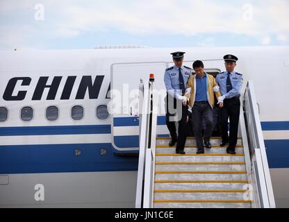 (170729)--Peking, 29. Juli 2017 (Xinhua)--Ren Biao (C), steigt aus einem Flugzeug unter Polizei-Eskorte bei Beijing Capital International Airport in Peking, Hauptstadt von China, 29. Juli 2017. Ren Biao, einer der meistgesuchten flüchtigen Chinas, hat kehrte nach China zurück und stellte sich in der Polizei, die Anti-Korruptions-Behörde sagte am Samstag. Ren, 44, ehemalige "tatsächliche Mehrheitsaktionär" Daluo Energie beliefert Unternehmen in Ost-China Jiangsu Province, floh in die karibische Nation von St. Kitts und Nevis im Januar 2014, nachdem er beschuldigt betrügerisch Kredite zu erhalten und die Herstellung von Fin Stockfoto