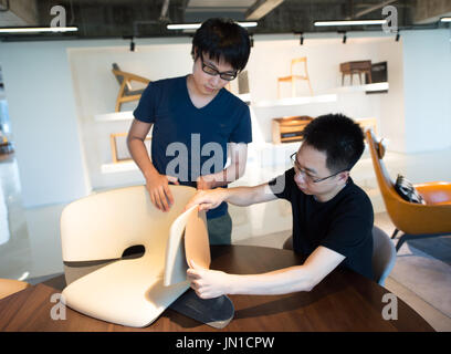 (170729)--HANGZHOU, 29. Juli 2017 (Xinhua)--Zhao Lei (R) und Zhang Jingxiang besprechen das Design eines Stuhls im Hauptquartier der MZGF in der ostchinesischen Provinz Zhejiang, Hangzhou 28. Juli 2017. Zhao Lei MZGF gegründet 2010 und dem design einer Vielzahl von Möbeln geeignet für modernes Leben. Chinas Möbelindustrie ist eine neue Welle von unabhängigen Designer-Marken, vor allem in Städten wie Beijing, Shanghai und Hangzhou umfassend. Die neue Generation von Designern legt mehr Wert auf die zeitgenössischen Ausdruck der chinesischen Elemente, das Fell kreative Dynamik hinzufügen Stockfoto