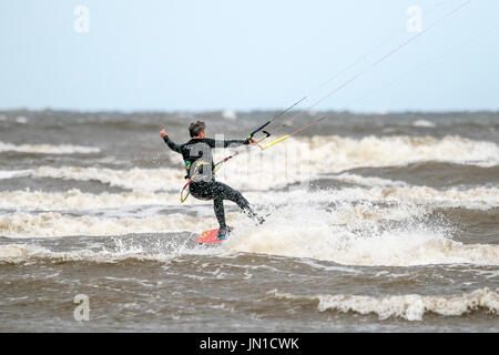 Southport, Merseyside, 29. Juli 2017. Großbritannien Wetter. Kite Boarder Kopf in die irische See, die Wellen auf die Flut an Southport Strand in Merseyside fahren. Stürmischen 25 km/h Wind macht nahezu perfekte Bedingungen um die Segel an dieser bekannten Kite boarding Hotspot zu füllen. Bildnachweis: Cernan Elias/Alamy Live-Nachrichten Stockfoto