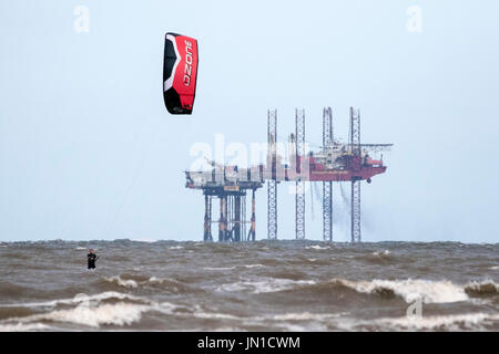 Southport, Merseyside, 29. Juli 2017. Großbritannien Wetter. Kite Boarder Kopf in die irische See, die Wellen auf die Flut an Southport Strand in Merseyside fahren. Stürmischen 25 km/h Wind macht nahezu perfekte Bedingungen um die Segel an dieser bekannten Kite boarding Hotspot zu füllen. Bildnachweis: Cernan Elias/Alamy Live-Nachrichten Stockfoto