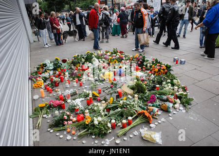 Hamburg, Deutschland. 29. Juli 2017. Blumen und Kerzen in Form eines Peace-Zeichen auf dem Bürgersteig vor dem Supermarkt, wo ein Mann eine andere Person getötet und verletzt sechs weitere Menschen in Hamburg, Deutschland, 29. Juli 2017, liegen. Foto: Markus Scholz/Dpa/Alamy Live News Stockfoto