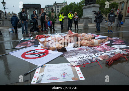 London, UK, 29. Juli 2017.  Eine Demonstration fand am Londoner Trafalgar Square, die Grausamkeit hinter Tierausbeutung verfügbar zu machen. Demonstranten erstellt einen blutigen menschlichen Haufen von Tierkörpern auf die Ausbeutung von Tieren für den menschlichen Verzehr bestimmt aufmerksam. Bildnachweis: Steve Bell/Alamy Live-Nachrichten Stockfoto