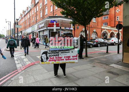 London, UK. 29. Juli 2017. Ein Demonstrant mit Plakaten. Protest und Vigil für Rashan Charles außerhalb Stoke Newington Polizeistation, der gestorben nachdem er gejagt und von der Polizei verhaftet. Penelope Barritt/Alamy Live-Nachrichten Stockfoto