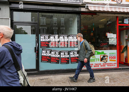 London, UK. 29. Juli 2017. Ein Mann geht vorbei an Nein zu Rassismus Plakat. Protest und Vigil für Rashan Charles außerhalb Stoke Newington Polizeistation, der gestorben nachdem er gejagt und von der Polizei verhaftet. Penelope Barritt/Alamy Live-Nachrichten Stockfoto