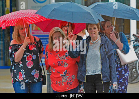 Bristol, UK. 29. Juli 2017. Großbritannien Wetter. Damen gefangen unter ihren Sonnenschirmen zu Beginn der neun Stunden von heavy Rain zu übergießen Bristol in Großbritannien ab. gesehen am Verkehr auf Whiteladies Straße. Bildnachweis: Robert Timoney/Alamy Live-Nachrichten Stockfoto