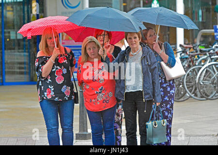 Bristol, UK. 29. Juli 2017. Großbritannien Wetter. Damen gefangen unter ihren Sonnenschirmen zu Beginn der neun Stunden von heavy Rain zu übergießen Bristol in Großbritannien ab. gesehen am Verkehr auf Whiteladies Straße. Bildnachweis: Robert Timoney/Alamy Live-Nachrichten Stockfoto