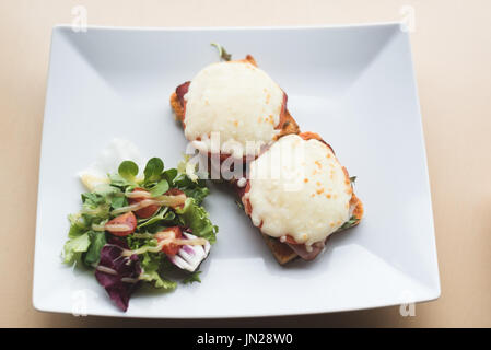 Erhöhte Ansicht von Sandwich mit Salat im Teller am Tisch serviert Stockfoto