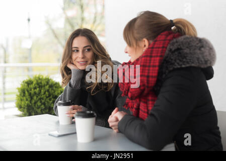 Lächelnden Freundinnen am Tisch im café Stockfoto