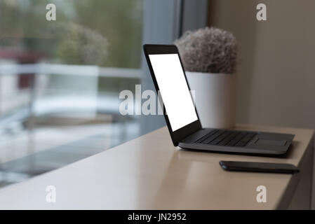 Nahaufnahme von Laptop und Smartphone auf Tisch Fenster im café Stockfoto