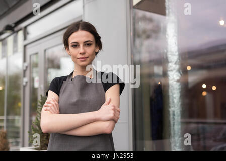 Porträt der Besitzerin mit Armen gekreuzt stehenden Café Stockfoto