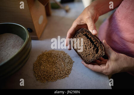 Mittleren Teil des senior Frau hält Brot in der Küche Stockfoto