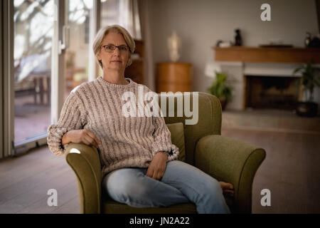 Porträt von senior Frau sitzt auf der Couch zu Hause Stockfoto