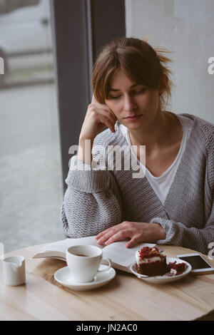 Schöne Frau Lesebuch im café Stockfoto
