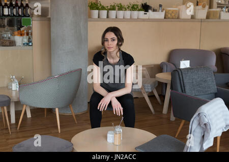 Porträt der Besitzerin sitzen auf Stuhl Om café