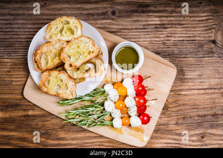 Tomaten-Käse und Brot-Häppchen auf Rosmarin-Spieße Stockfoto