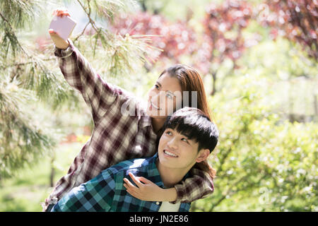 Junges Paar unter Selbstbildnis mit Handy Stockfoto