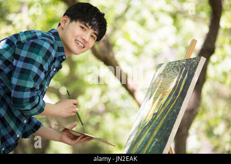 Junger Mann malen im freien Stockfoto