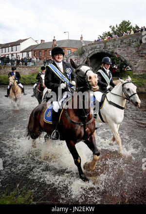 Pferd und Reiter nehmen an das Reiten der Marken Ford auf dem Fluß Esk, neben der Römerbrücke in Musselburgh, East Lothian, während des jährlichen Musselburgh-Festival, organisiert von der ehrlichen unten Association Teil. Stockfoto