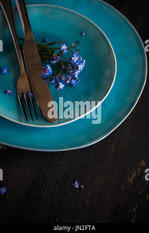 Sommer Blumen Tischdekoration mit leuchtend blauen Vergissmeinnicht Blumen auf Holztisch Stockfoto