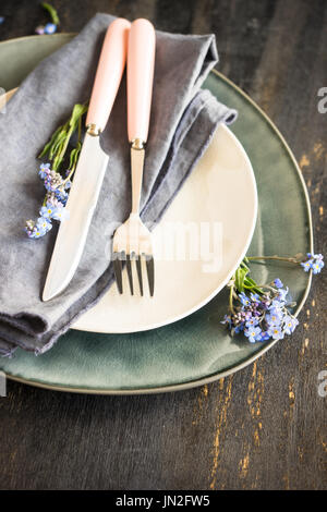 Sommer Blumen Tischdekoration mit leuchtend blauen Vergissmeinnicht Blumen auf Holztisch Stockfoto