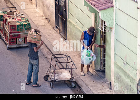 Zwei Männer machen eine Lieferung an eine Wohnung in Havanna, Kuba. Stockfoto