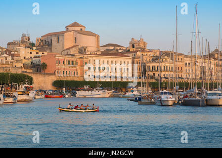 Syrakus Sizilien Stadtbild, Ansicht einer Rudermannschaft, die im Hafen (Porto Grande) von Ortygia (Ortigia), Syrakus, Sizilien, trainiert. Stockfoto