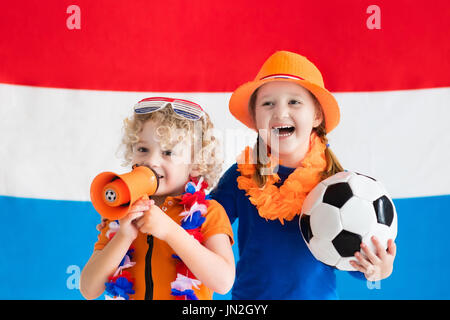 Kinder jubeln und Unterstützung der niederländischen Fußball-Nationalmannschaft. Kinder-Fans und Unterstützer der Niederlande während der Fußball-Europameisterschaft. Junge und Mädchen aus Hollan Stockfoto