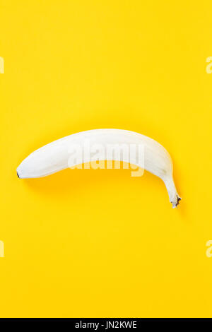 eine weiße Banane auf einem gelben Hintergrund. Farben haben umgekehrt. Spaß, minimal und schrulligen Farbe Still Life Fotografie Stockfoto