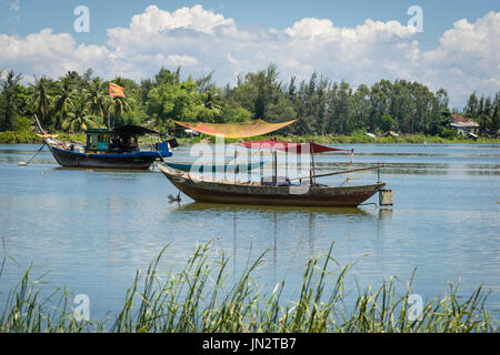 Altmodische vietnamesische Fischerboot und Ruderboot vor Anker am Thu Bon Fluss außerhalb von Hoi An Vietnam Stockfoto