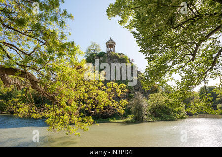 Temple De La Sibylle, inspiriert durch den Tempel der Vesta in Tivoli an der Spitze eines Felsens inmitten eines Sees mit Bäumen im Vordergrund - Parc des B Stockfoto