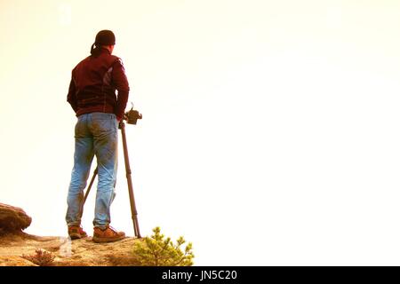 Silhouette des Landschaftsfotografen auf Gipfel über neblige Tal Stockfoto