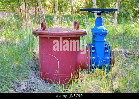 Ausbau Altleitung Getränk Wasserleitungen mit neuen blauen Ventil und neue blaue gemeinsame Mitglieder beigetreten. Neue Ablassventil. Metall korrodiert Textur. Stockfoto
